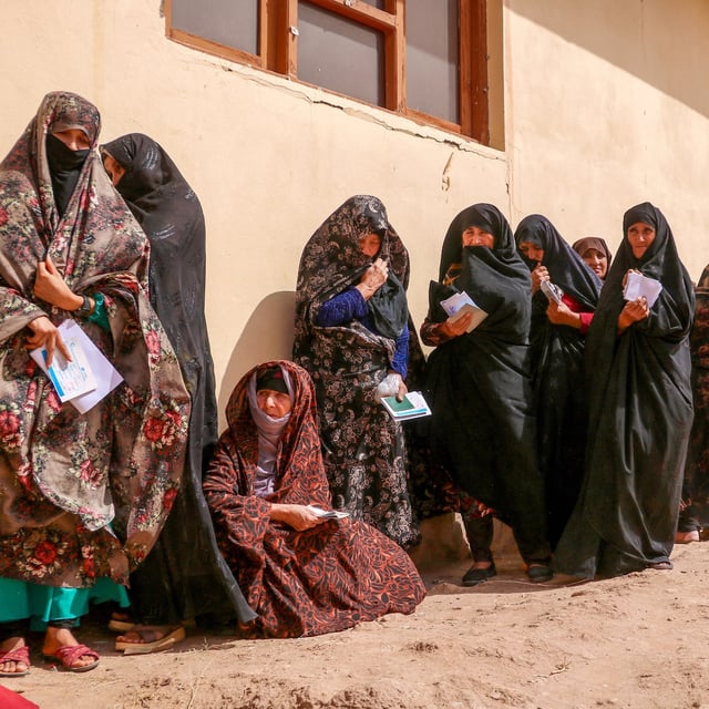 Afghan women wait to receive fiscal aid from Afghan Red Crescent Society (ARCS) in Kohsan district of Herat province on September 25, 2024. (Photo by Mohsen KARIMI / AFP) (Photo by MOHSEN KARIMI/AFP via Getty Images)