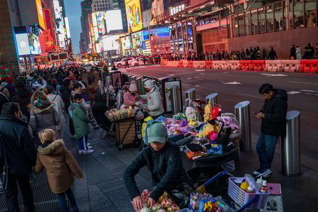 People display merchandise for pedestrians around Times Square, in New York, U.S., December 25, 2023. REUTERS/Eduardo Munoz/File Photo