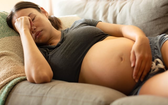 A tired stressed pregnant woman resting