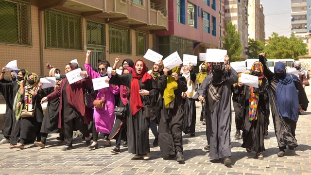 TOPSHOT - Afghan women hold placards as they march to protest for their rights, in Kabul on April 29, 2023. - Afghan women protested in Kabul on April 29, defying a dissent crackdown to voice opposition to foreign nations formally recognising the Taliban government ahead of a UN summit next week. (Photo by AFP) (Photo by -/AFP via Getty Images)