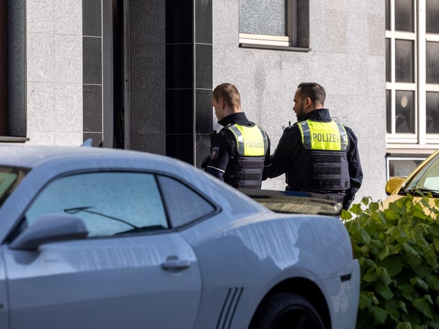 29 September 2024, North Rhine-Westphalia, Essen: Two police officers stand in front of the entrance to the building. 31 people were injured in several fires - two children are in mortal danger. The emergency services were deployed to three locations at the same time, according to the fire department. The suspect was arrested after he allegedly drove a van into a store, a police spokesman said. Photo: Thomas Banneyer/dpa (Photo by Thomas Banneyer/picture alliance via Getty Images)
