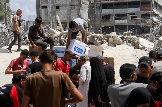 Palestinians gather to receive aid, including food supplies provided by World Food Program (WFP), outside a United Nations distribution center, amid the Israel-Hamas conflict, in Jabalia in the northern Gaza Strip, August 24, 2024. REUTERS/Mahmoud Issa/File Photo