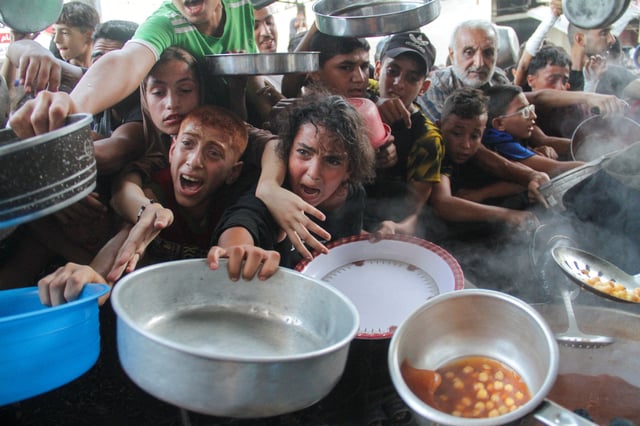 Palestinians gather to receive food cooked by a charity kitchen, amid the Israel-Hamas conflict, in the northern Gaza Strip, September 11, 2024. REUTERS/Mahmoud Issa/File Photo
