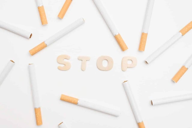 stop text and cigarettes over white backdrop