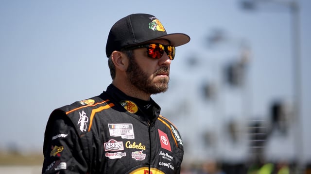 KANSAS CITY, KANSAS - SEPTEMBER 09: Martin Truex Jr., driver of the #19 Bass Pros Shops Toyota, walks the grid during qualifying for the NASCAR Cup Series Hollywood Casino 400 at Kansas Speedway on September 09, 2023 in Kansas City, Kansas.