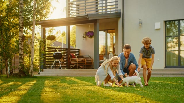 A family is seen together in their backyard.