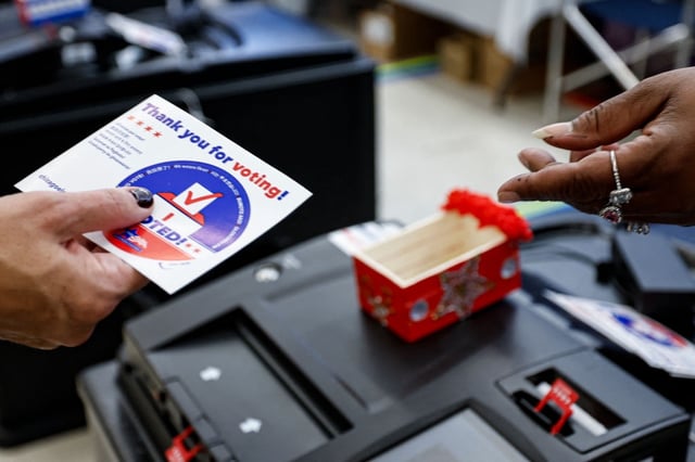 A woman receives an I Voted sticker after casting her ballot on the second day of early voting in the 2024 presidential election at the Board of Elections Loop Super Site in Chicago, Illinois, on October 4 2024. (Photo by KAMIL KRZACZYNSKI/AFP via Getty Images)
