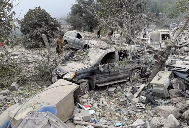 Lebanese army soldier stands near destroyed vehicles at a site damaged by an Israeli air strike in the Christian-majority region of Aitou in north Lebanon, the Lebanese health ministry said, October 14, 2024. REUTERS/Omar Ibrahim