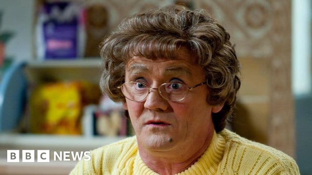 Brendan O'Carroll as Agnes Brown, wearing a yellow cardigan on the show's kitchen set