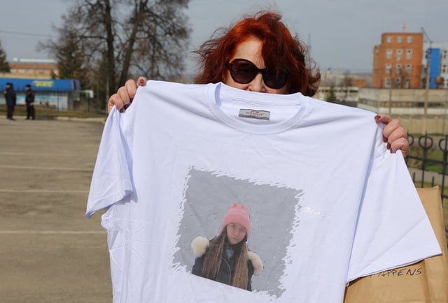 A supporter of Russian citizen Alexei Moskalyov, who was convicted of discrediting the country's armed forces in the course of Russia-Ukraine military conflict, holds a t-shirt with a portrait of Moskalyov's daughter Masha outside a courthouse in the town of Yefremov in the Tula region, Russia, April 6, 2023. REUTERS/Evgenia Novozhenina/File Photo