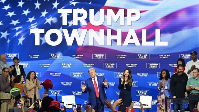 Donald Trump, with moderator and South Dakota Governor Kristi Noem (R), arrives for a town hall at the Greater Philadelphia Expo Center and Fairgrounds in Oaks, Pennsylvania, on October 14, 2024. (Photo by Jim WATSON / AFP)