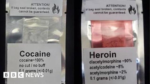 A photo of two labelled batches of drugs sold by Kalicum and Nyx. One package is labelled '0.1 grams of Cocaine' while another is labelled '0.1 grams of Heroin.'