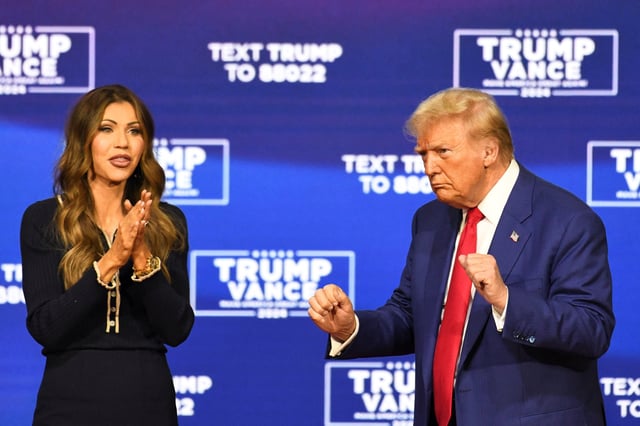 Republican presidential nominee former U.S. President Donald Trump and South Dakota Governor Kristi Noem react during a town hall campaign event in Oaks, Pennsylvania, U.S., October 14, 2024.