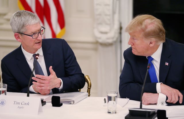 Apple CEO Tim Cook talks with U.S. President Donald Trump as they participate in an American Workforce Policy Advisory Board meeting in the White House State Dining Room in Washington, U.S., March 6, 2019. REUTERS/Leah Millis/File Photo