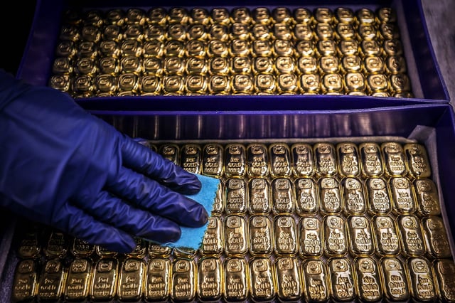 A worker polishes gold bullion bars