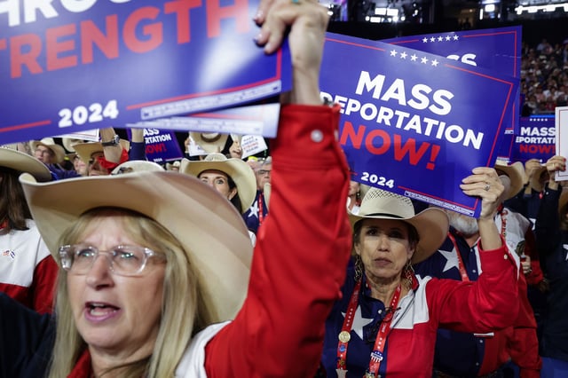MILWAUKEE, WISCONSIN - JULY 17: People hold signs that read "Mass Deportation Now!" on the third day of the Republican National Convention at the Fiserv Forum on July 17, 2024 in Milwaukee, Wisconsin. Delegates, politicians, and the Republican faithful are in Milwaukee for the annual convention, concluding with former President Donald Trump accepting his party's presidential nomination. The RNC takes place from July 15-18.  (Photo by Alex Wong/Getty Images)