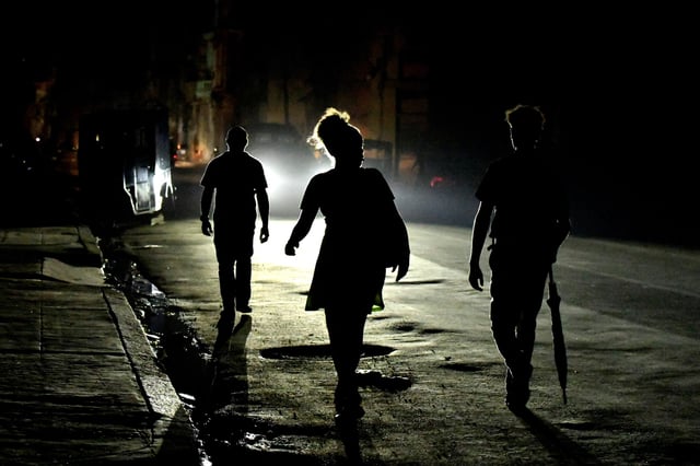 People walk in the street at night as Cuba is hit by an island-wide blackout, in Havana, Cuba, October 18, 2024. REUTERS/Norlys Perez