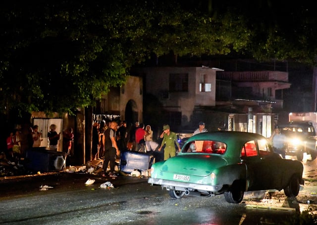 Cuban police and military stand next to debris used to block a street during a protest against a blackout, after opening the street up to traffic, in Havana, Cuba October 19, 2024. REUTERS/Norlys Perez/File Photo