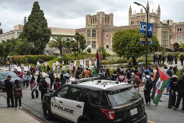 Pro-Palestinian protesters carry signs and march along the campus of UCLA on May 23, 2024, in Los Angeles.