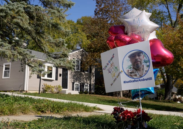 A makeshift memorial of flowers, balloons and a sign reading, among other things, “Justice for Andre Hill” are displayed Wednesday afternoon in the tree lawn in front of a home on Oberlin Drive next door to the home where Andre Hill was fatally shot.  Members of the jury in the trial of former Columbus police officer Adam Coy were taken to the scene of the shooting on Wednesday afternoon. Franklin County Common Pleas Judge Stephen McIntosh ordered that the display be removed before the jurors viewed the residence and others around it. The display was put back in its place once the jurors left.