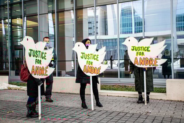 Protesters hold signs outside the Franklin County Common Pleas Courthouse after the arraignment of Adam Coy, the former Columbus Police officer who shot and killed Andre Hill, in Columbus, Ohio, on Feb. 5, 2021.