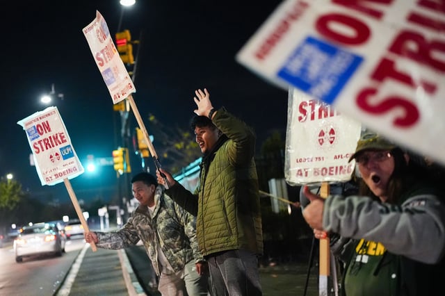 Boeing employees work the picket line in Renton, Washington, late Wednesday after union members voted to reject a new contract offer from the company.