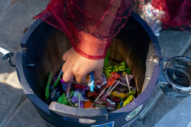 Kids grab candy out of a bucket during the fourth annual Halloween Stroll and Trunk-or-Treat Car Show Presented by Romain Cross Pointe in downtown Evansville, Indiana on Saturday, Oct. 26, 2024.