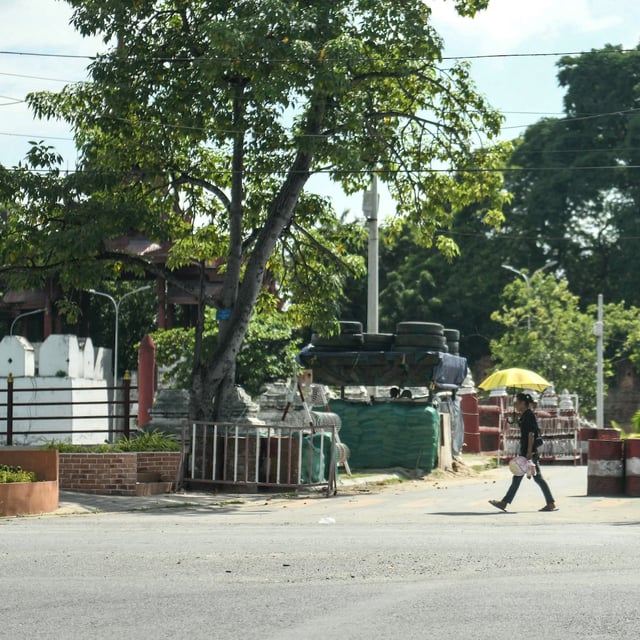 A man walks past military barricades in Mandalay on October 23, 2024. On the outskirts of Mandalay nervous Myanmar soldiers man a checkpoint just kilometres away from rebels who have set their sights on the former royal capital of 1.5 million people. (Photo by AFP) / To go with 'MYANMAR-COUP-CONFLICT' (Photo by STR/AFP via Getty Images)