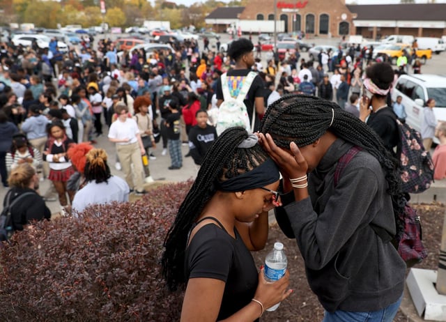 Students stand in a parking lot near the Central Visual & Performing Arts High School in St. Louis, on Oct. 24, 2022.