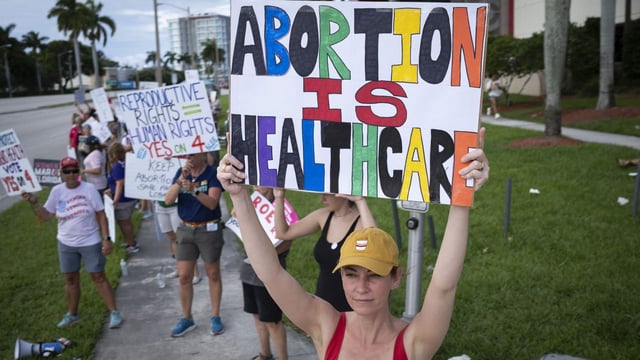 People hold up signs during a pro-abortion rights rally on the second anniversary of the Supreme Court ruling to overturn Roe v. Wade, in West Palm Beach, Florida, on June 24, 2024. Photo: Marco Bello/AFP via Getty Images