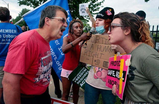 FILE – Steve Sallwasser, of Arnold, debates Brittany Nickens, of Maplewood, during competing rallies outside Planned Parenthood of Missouri, following the U.S. Supreme Court decision to overturn Roe v. Wade, June 24, 2022, in St. Louis. (Robert Cohen/St. Louis Post-Dispatch via AP, File)