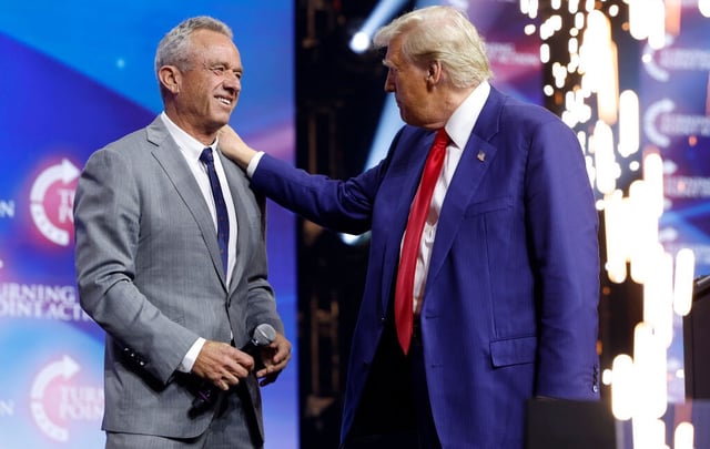 Image of Donald Trump on stage with his hand on the shoulder of Robert F. Kennedy, Junior.