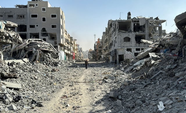 A Palestinian man walks past the rubble after Israeli forces withdrew from the area around Kamal Adwan hospital, amid the ongoing Israel-Hamas conflict, in Jabalia, in the northern Gaza Strip October 26, 2024.