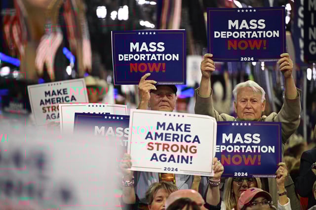 Attendees hold "mass deportations now!" sign during the Republican National Convention in Milwaukee, on July 17, 2024. 
