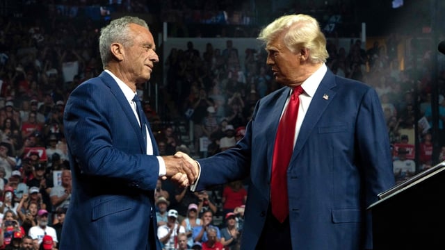 Former Republican presidential candidate Robert F. Kennedy Jr. and former US President and Republican presidential candidate Donald Trump shake hands during a campaign rally at Desert Diamond Arena on August 23, 2024 in Glendale, Arizona. 