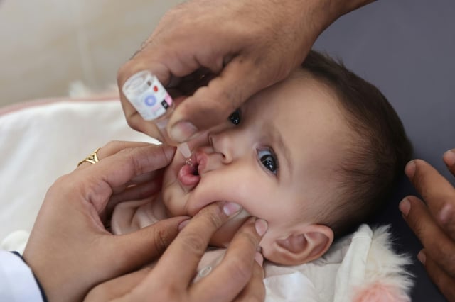 A Palestinian child is vaccinated against polio at Abdel Aziz Rantissi hospital in Gaza City on November 2