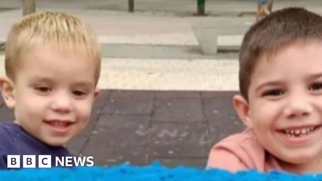 Rubén and Izan Matías, two young boys, are stood outside and are smiling at the camera. The photo only shows their heads and shoulders