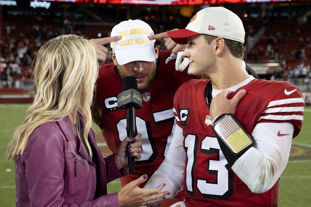 San Francisco 49ers defensive end Nick Bosa (97) points at his “Make America Great Again” cap while quarterback Brock Purdy (13) is interviewed by Melissa Stark (left) after the NFL football game against the Dallas Cowboys in Santa Clara, Calif., Oct. 27, 2024.