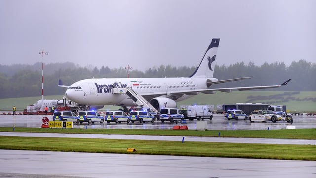 Police cars stay in front of an Iran Air aircraft at the Hamburg Airport in Hamburg, Germany, Monday, Oct. 9, 2023. Officials say flights to and from Hamburg Airport were suspended for about 1 1/2 hours after authorities received a threat to a plane that arrived from Iran. (Jonas Walzberg/dpa via AP)