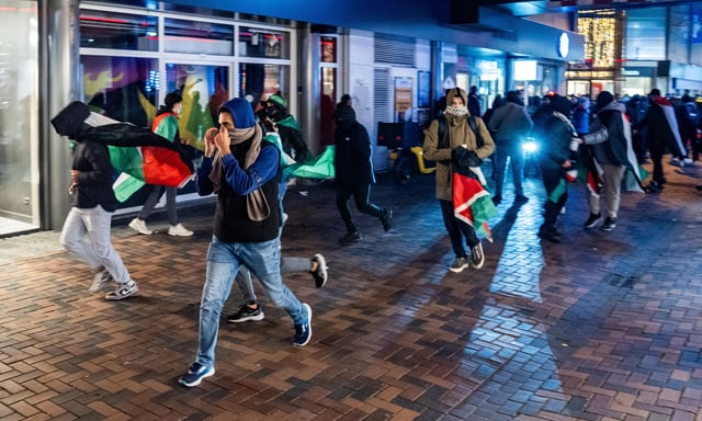 Manifestants courant avec des drapeaux palestiniens avant le match entre Ajax et Maccabi Tel Aviv, à Amsterdam, le 7 novembre 2024. Des supporters israéliens ont été victimes de lynchages.