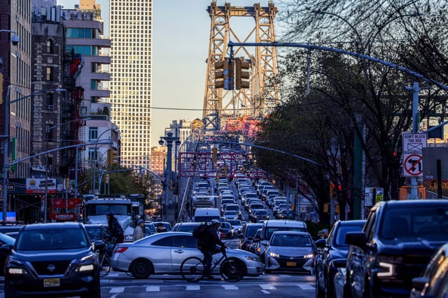 Pedestrians, cyclists and cars move along Delancey Street in New York City on Nov. 13, 2024.