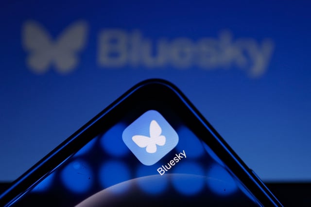 This illustration photograph taken on November 12, 2024, shows the logo of social media platform Bluesky displayed on a mobile telephone and tablet, in Paris. The bluesky social network has soared to one of the top positions in social network downloads in app stores in the past week since the US election. The company reported a recent gain of 700,000 new users joining the social media platform, an alternative to X (formerly known as Twitter). (Photo by Ian LANGSDON / AFP) (Photo by IAN LANGSDON/AFP via Getty Images)