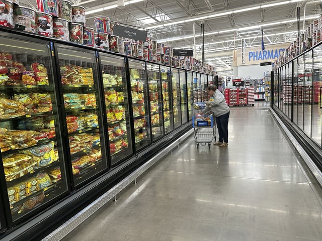 A lone shopper places items in her cart in the frozen food aisle of a Walmart store Thursday, Nov. 14, 2024, in Englewood, Colo.