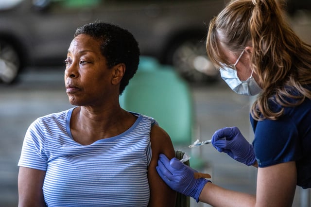 Denise Fractious, 68, of Pasadena, receives her Covid vaccine during a flu and Covid-19 vaccination clinic at Kaiser Permanente Pasadena on Oct. 12, 2023, in Pasadena, Calif.