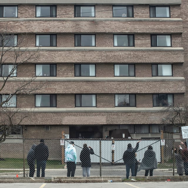 Family members wave to a relative as they stand outside the Eatonville Care Centre in Toronto, Saturday, April 18, 2020. THE CANADIAN PRESS/Chris Young