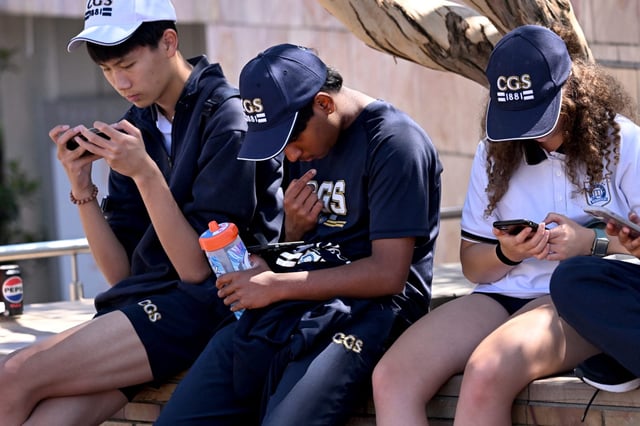 Students look at their phones in Melbourne on Nov. 28, 2024. Australia&#39;s lawmakers passed a bill that would ban children under 16 from social media on Friday.