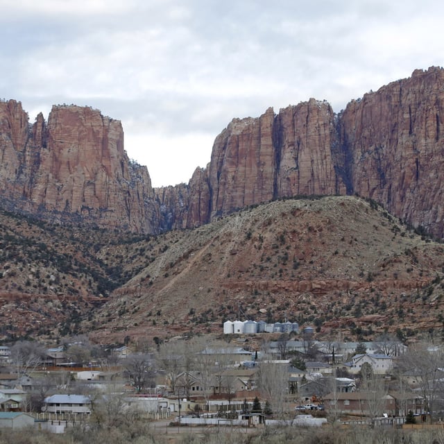This photo shows Hildale, Utah, sitting at the base of Red Rock Cliff mountains, with its sister city, Colorado City, Ariz., in the foreground, Dec. 16, 2014. Samuel Bateman declared himself a prophet in 2019 and formed an offshoot of the FLDS across the neighboring communities of Colorado City and Hildale.