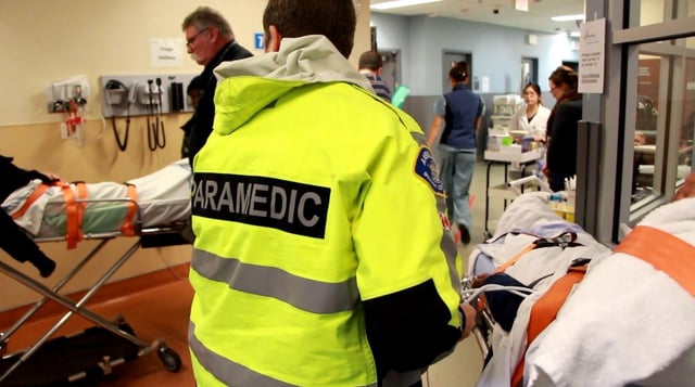 A paramedic tends to an overdose patient in the St. Paul’s Hospital ambulance bay