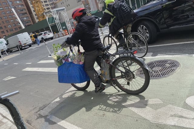A delivery worker rides an e-bike in Manhattan on April 19, 2024.