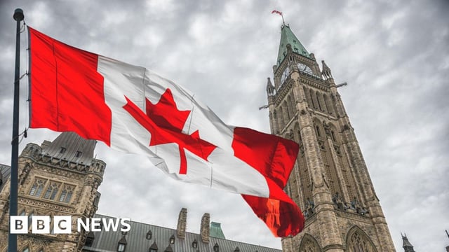 A photo of the Canadian flag flying in front of Parliament Hill in Ottawa, Canada.